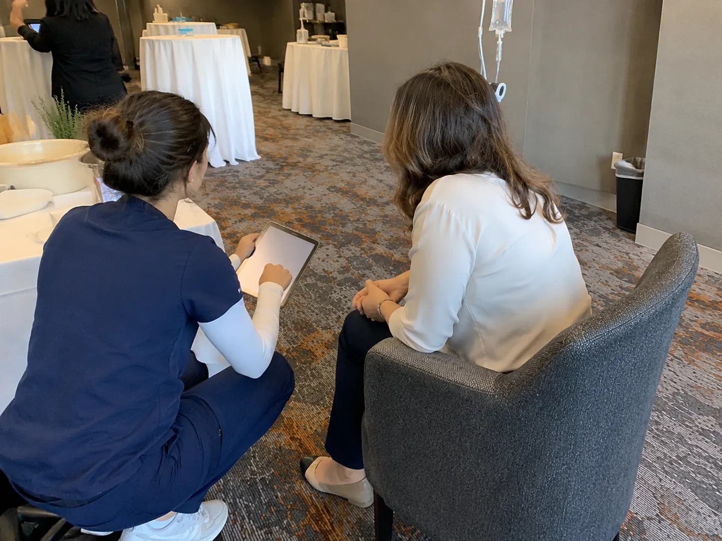 Nurse reviewing a health screening on a tablet with an employee before an onsite IV